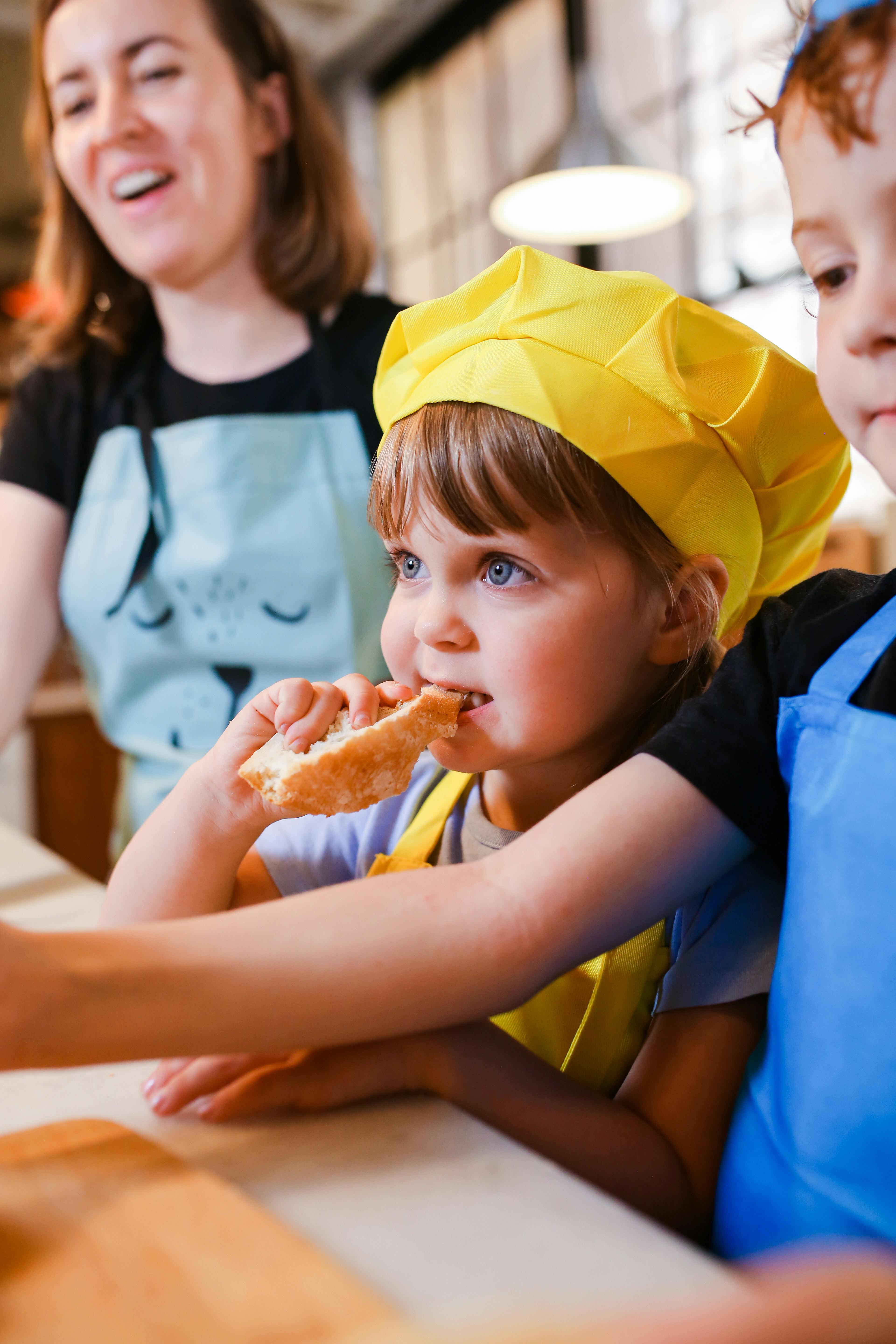 boy in blue and yellow shirt eating bread