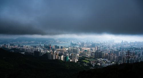 Free Aerial view of Hong Kong's skyline under dark clouds highlighting urban architecture. Stock Photo