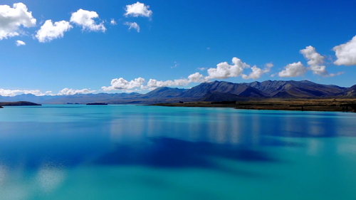 Free Stunning view of a turquoise mountain lake with scenic clouds and serene landscape. Stock Photo