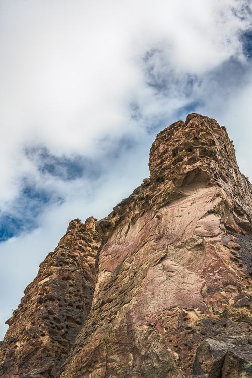 Free From below of rough mount with uneven surface located against cloudy sky in highlands Stock Photo