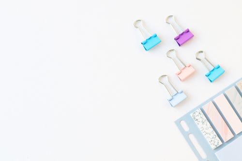 Free Vibrant stationery clips and paper strips on a white background with space for text. Stock Photo