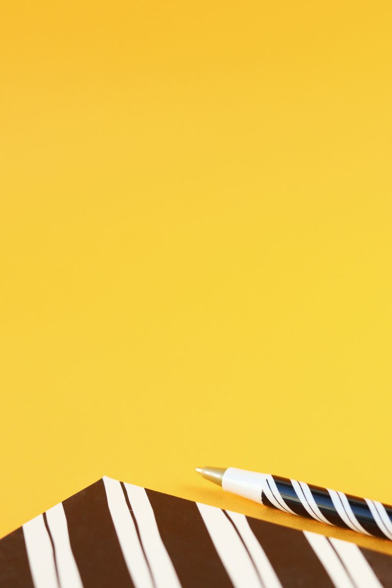 Notebook and pen on a yellow background