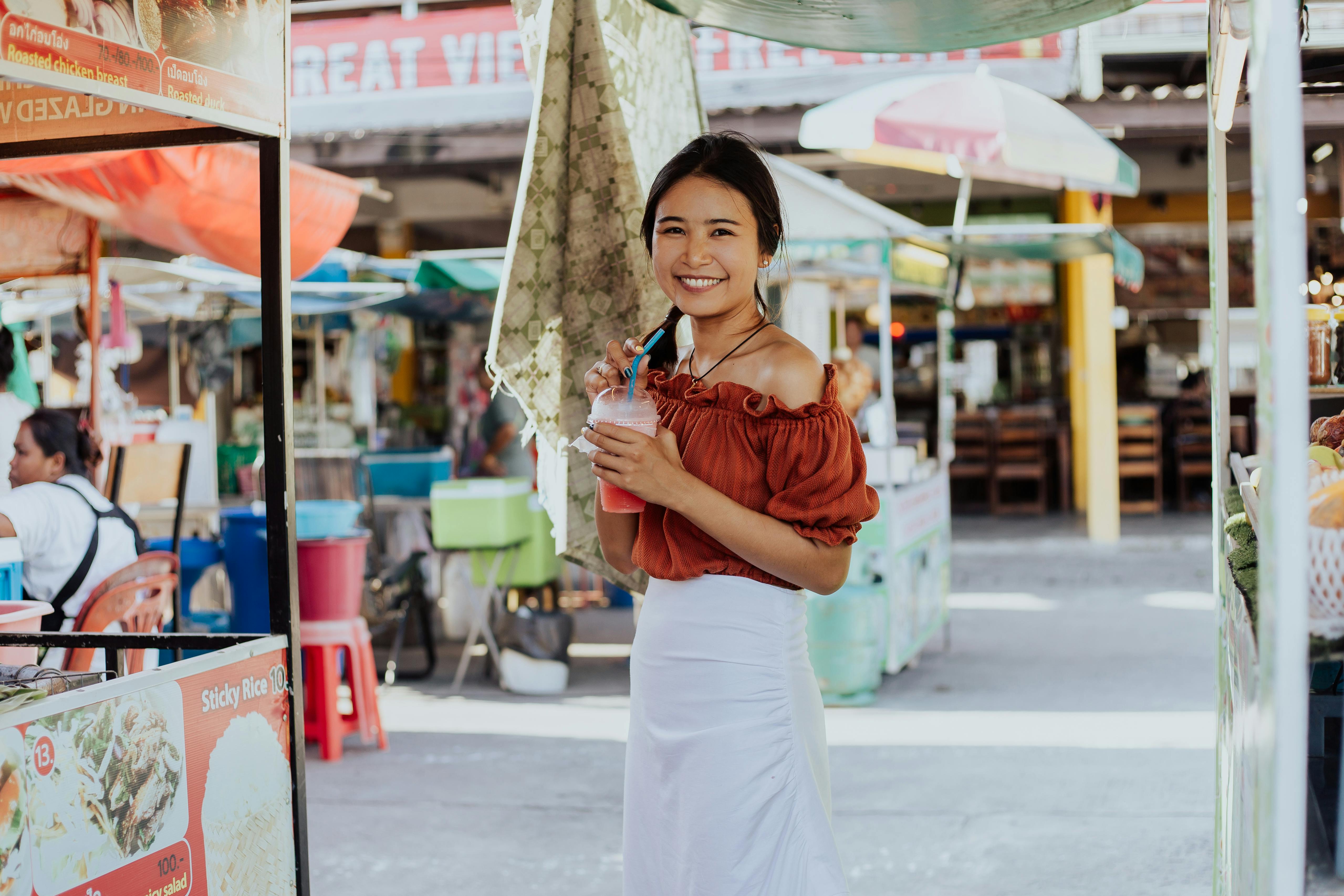 a woman smiling and holding a smoothie drink