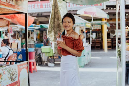 A Woman Smiling and Holding a Smoothie Drink