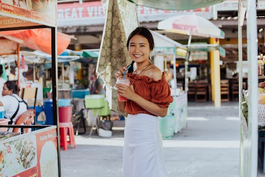 Cheerful woman holding a drink, enjoying her time at a vibrant Thai street market.