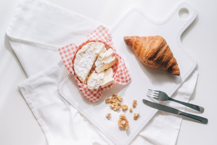 White Cheese Beside A Croissant On White Board