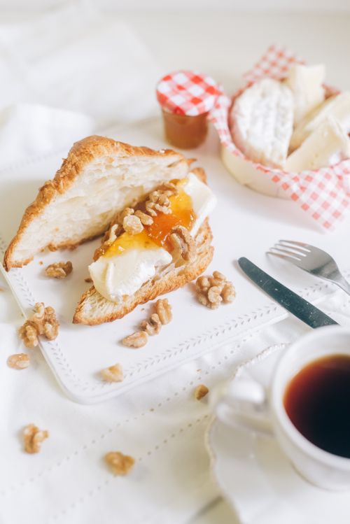Free Close-up of a croissant with cheese and jam on a plate with walnuts, perfect breakfast treat. Stock Photo