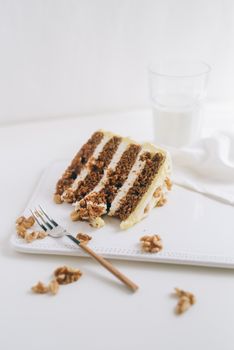 Close-up of a carrot cake slice with creamy layers and walnuts, perfect for dessert indulgence.