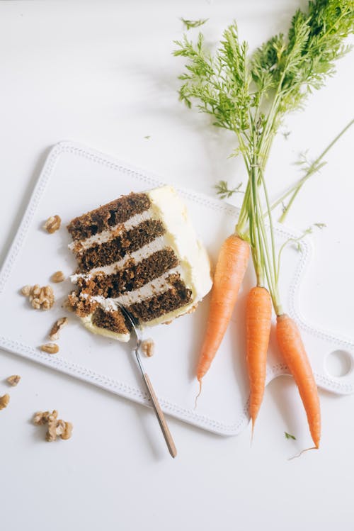 Free Sliced Cake with Nuts Beside a Bunch of Carrots Stock Photo