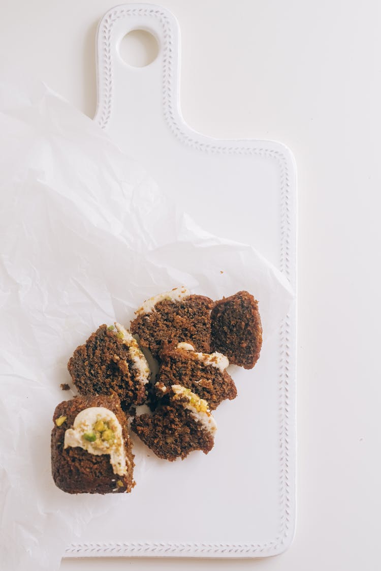 Sliced Cake On The White Paper On Top Of The Chopping Board