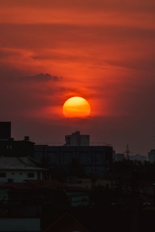 Free Picturesque bright sun setting over multistory buildings of residential district of modern city Stock Photo