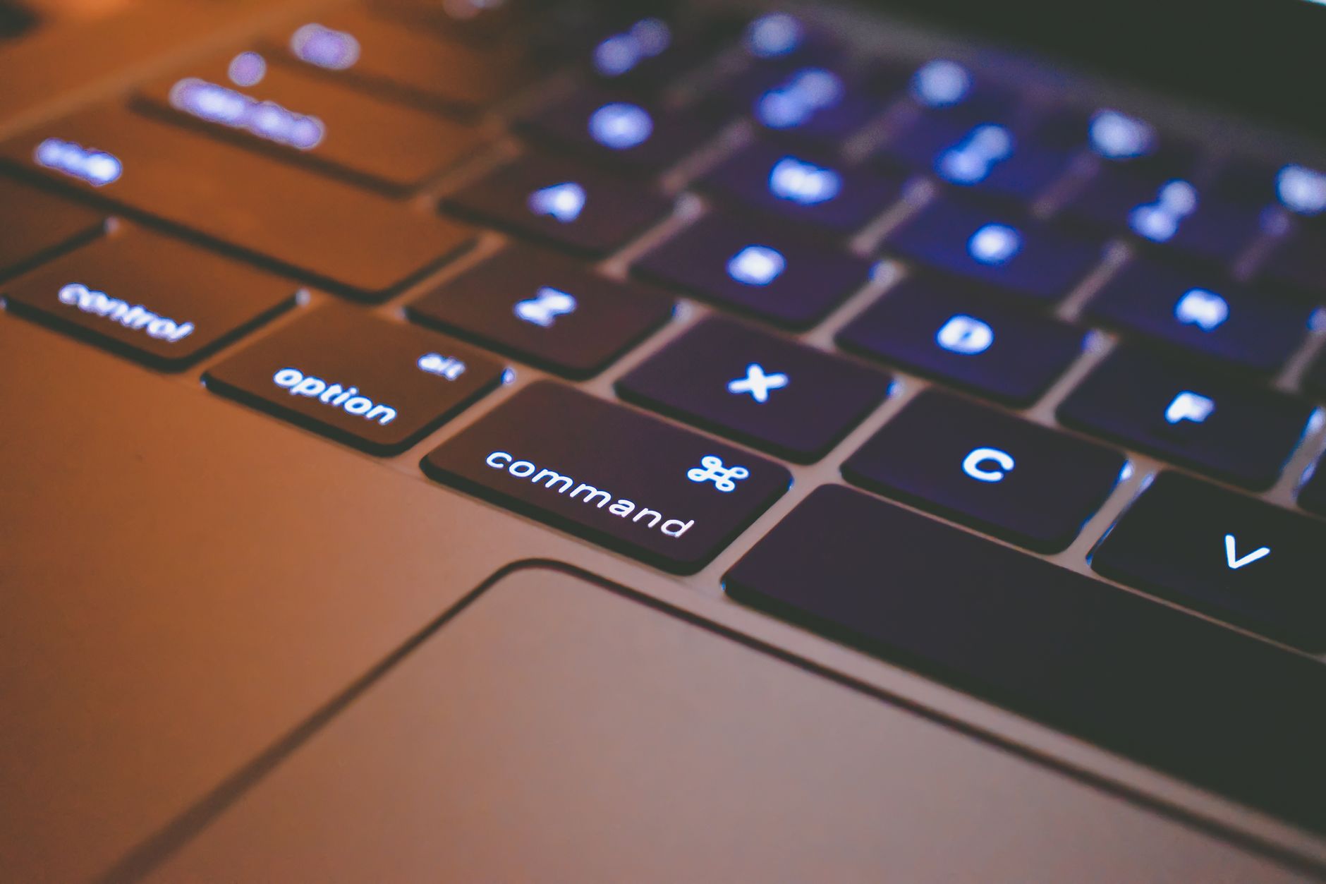 High-quality image of a backlit laptop keyboard focusing on command and option keys.