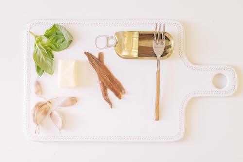 Free Canned Anchovies with Garlic, Butter and Herbs on a Cutting Board  Stock Photo