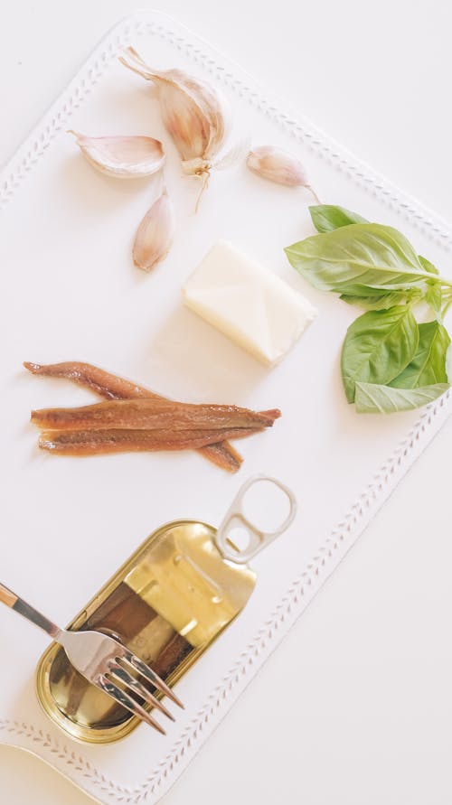 Free Canned Anchovies with Garlic, Butter and Herbs on a Cutting Board  Stock Photo