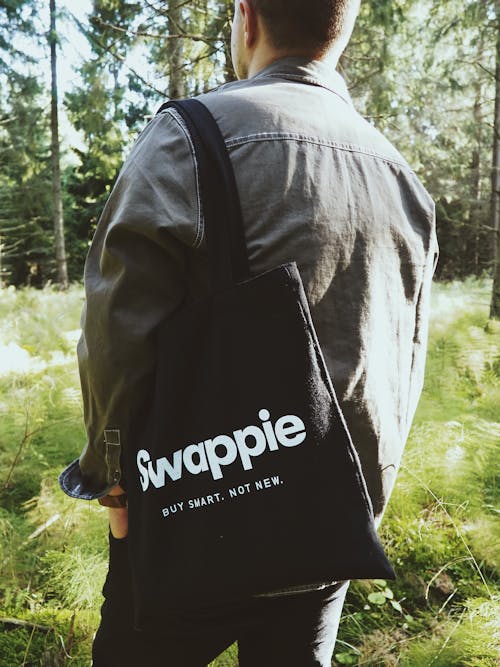 Man Carrying A Black and White Swappie Tote Bag