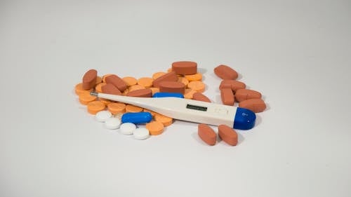 Free Prescription Drugs and Thermometer On Gray Surface Stock Photo