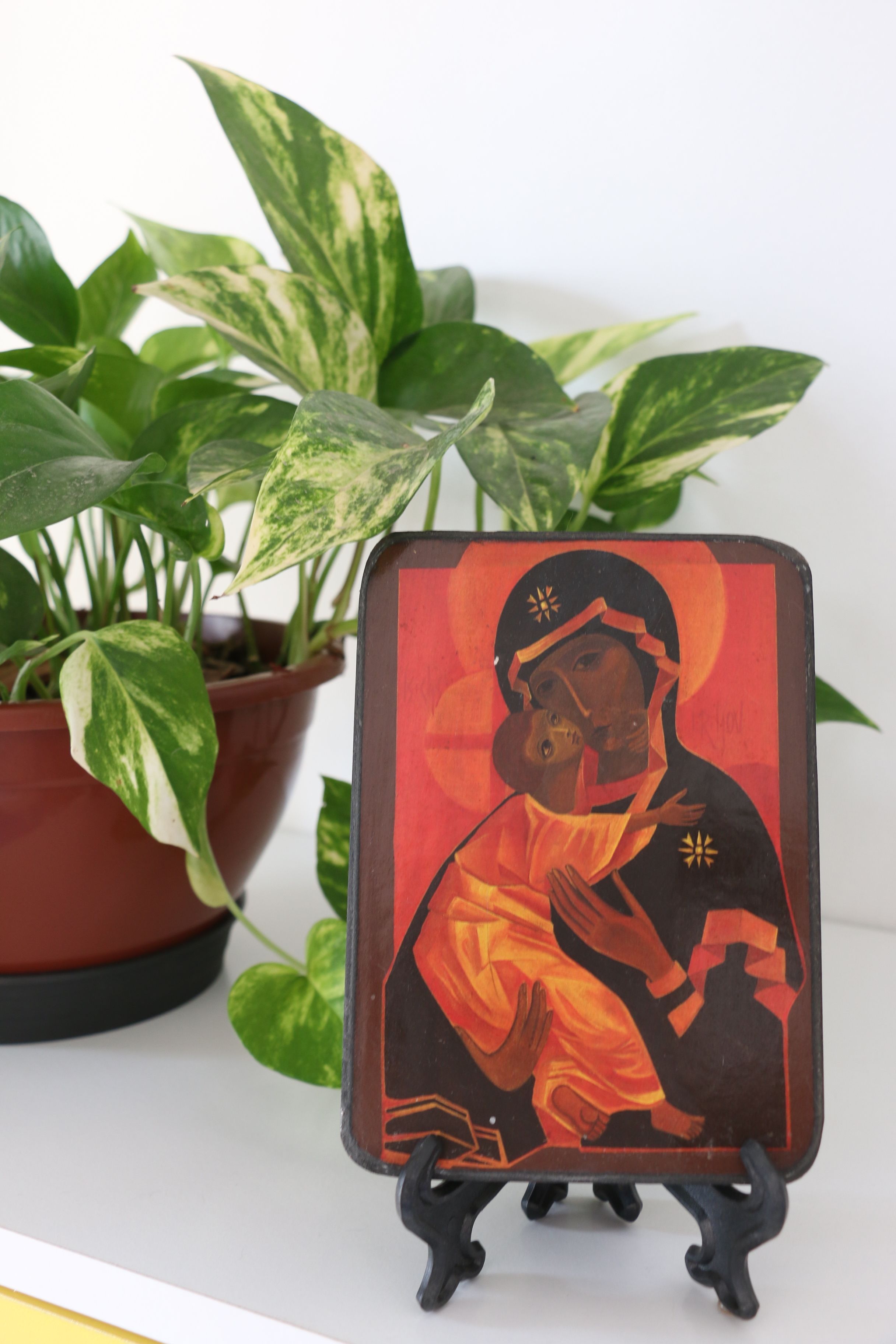 Icon art with potted plant on display stand indoors, São Paulo.