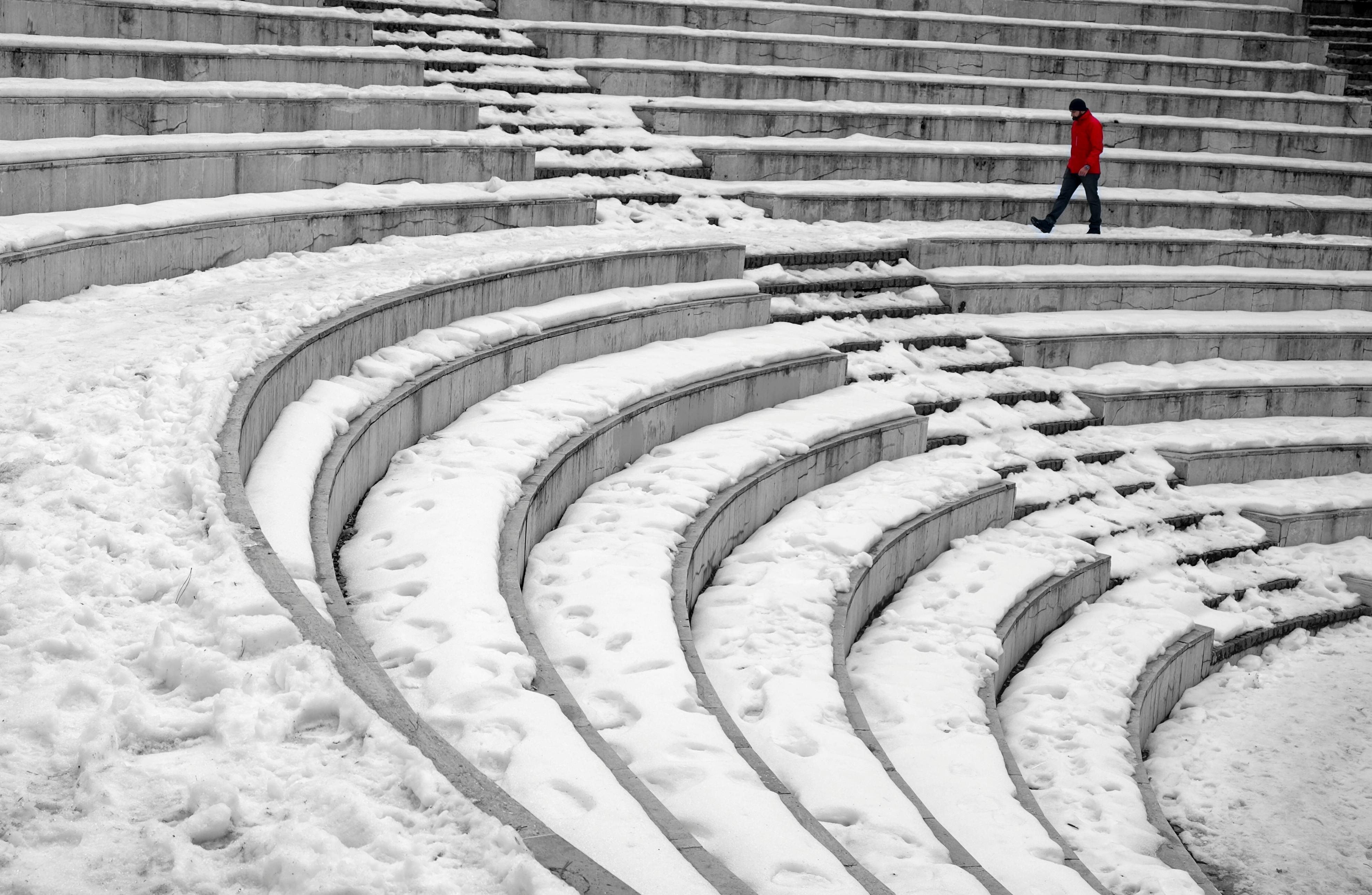 Free Anonymous male traveler in outerwear strolling on old staircase covered with snow in wintertime Stock Photo