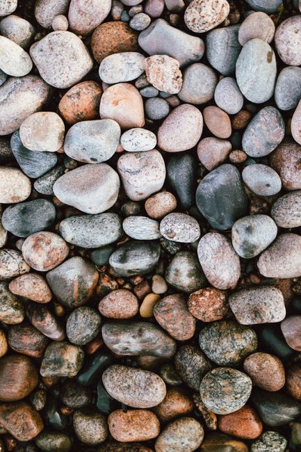 Top view abstract background of numerous smooth pebbles of different sizes and shapes