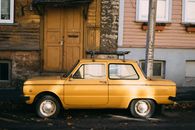 Yellow retro car parked outside old building