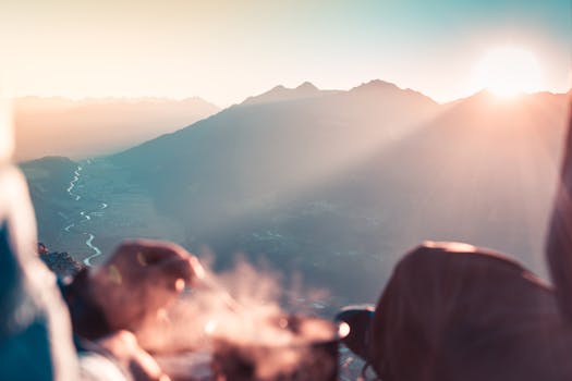 Experience a breathtaking sunrise over the Tiol Alps, capturing misty valleys and sunrays.