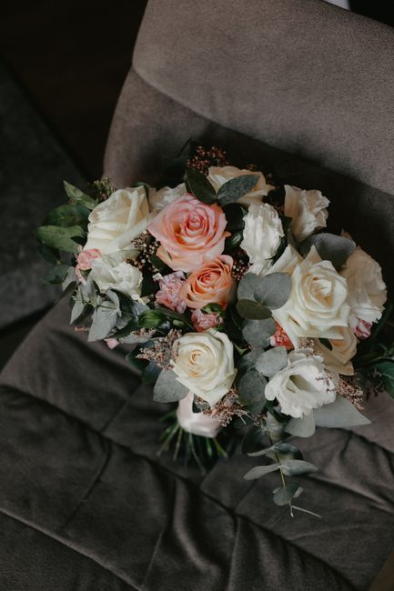From above of fresh bunch of blooming flowers with green leaves on gray cozy sofa