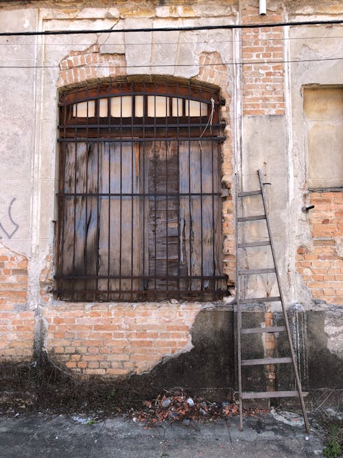 Free Abandoned Concrete Structure with a Ladder Near the Window Stock Photo