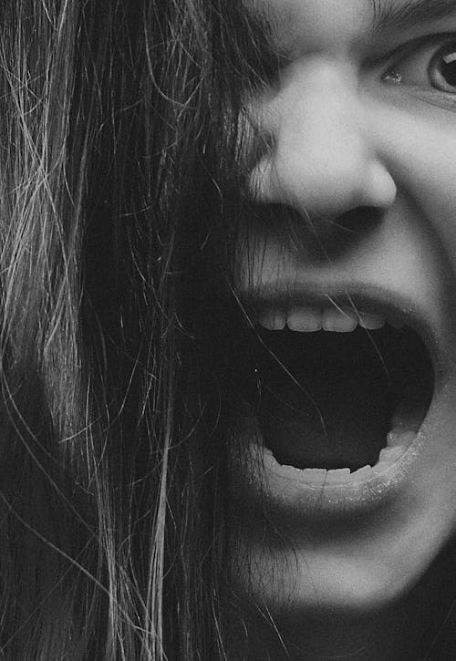 Free Grayscale close-up of a woman's face expressing emotion with open mouth. Stock Photo