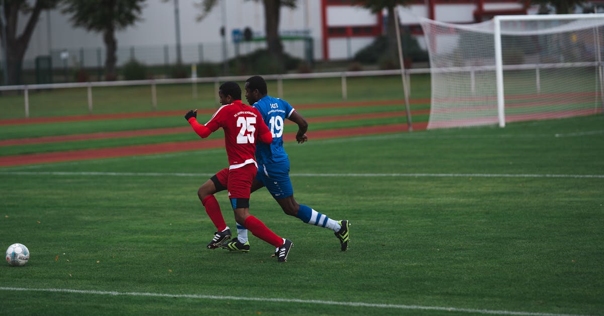 Players in action on a soccer field, chasing the ball during a match.
