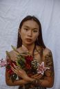 白色背景下，一位年轻女子手持充满活力的花束，肖像迷人