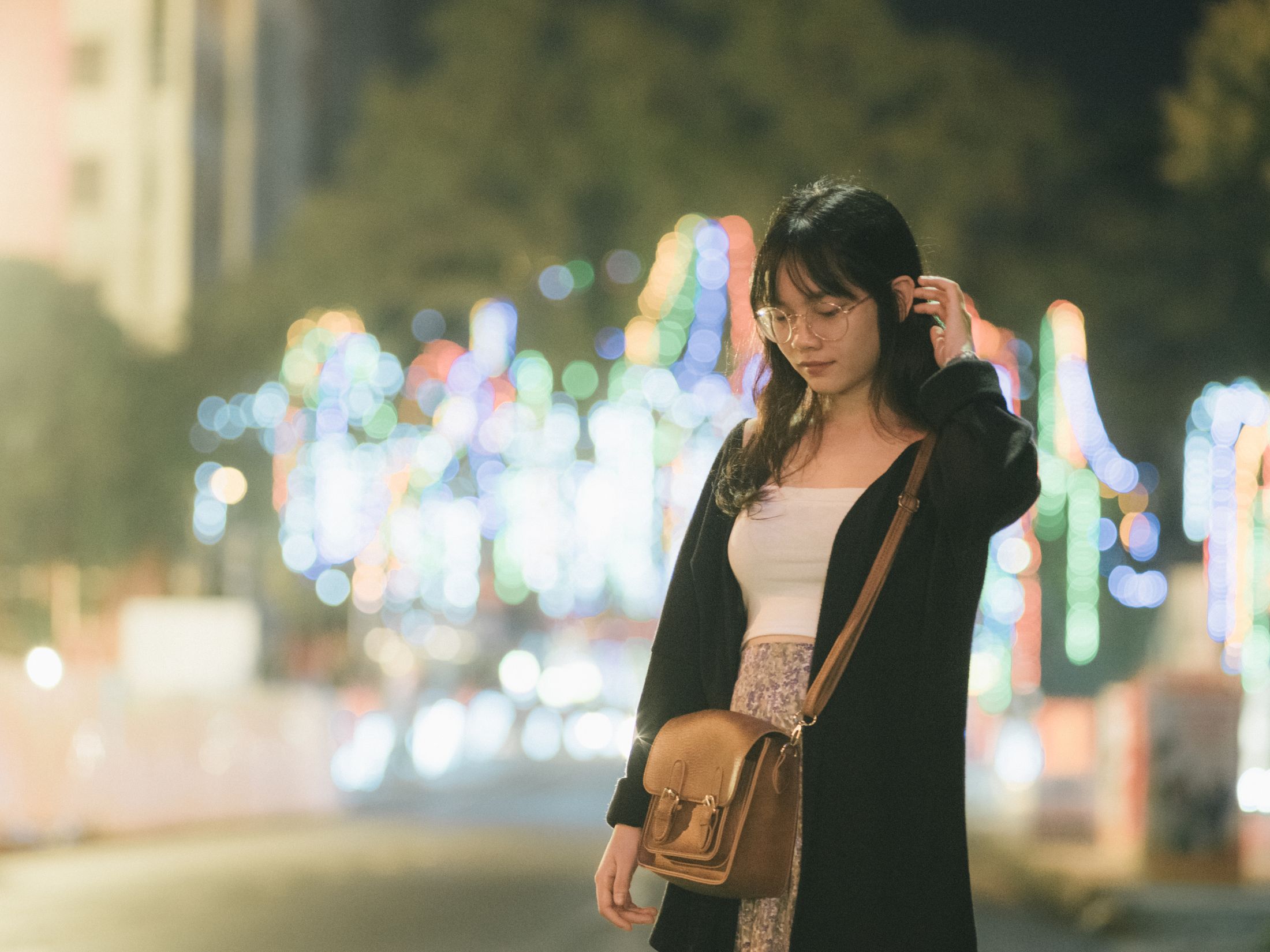 A woman on a bokeh-lit street at night. Photo by Q. Hưng Phạm on Pexels