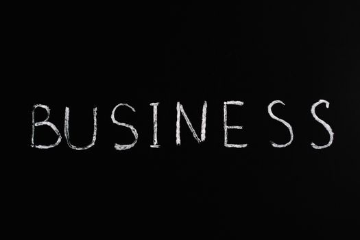 White chalk letters spelling 'BUSINESS' on a blackboard. Simple yet powerful conceptual design. 5598298