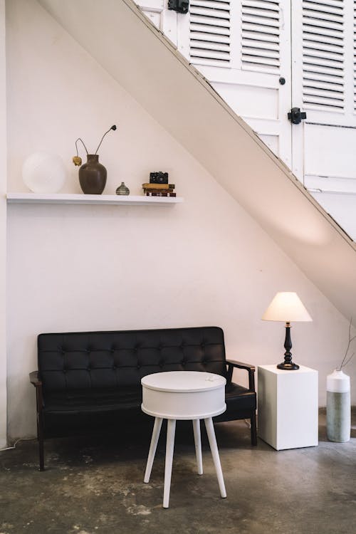 Black Sofa beside a White Wooden Table 