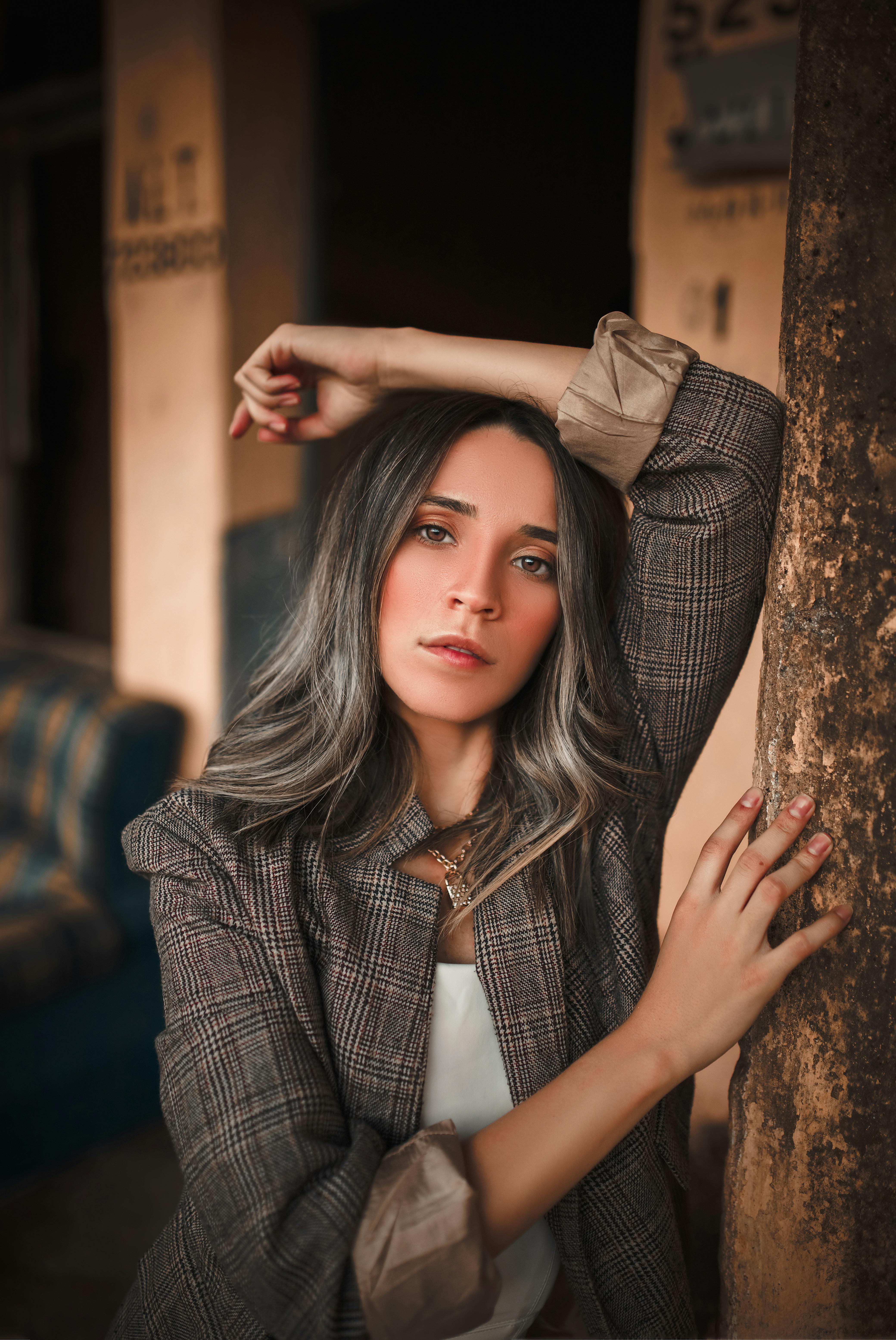 Portrait of a fashionable woman posing indoors with a confident expression, showcasing elegant attire.