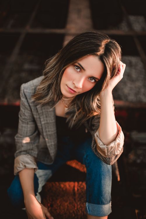 Free Stylish woman posing confidently in casual wear outdoors, captured in warm lighting. Stock Photo