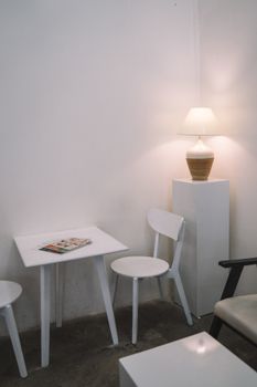 A cozy indoor café corner featuring minimalist furniture and ambient lighting.