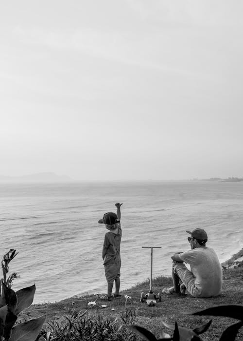 Man and Child Standing on Beach Shore