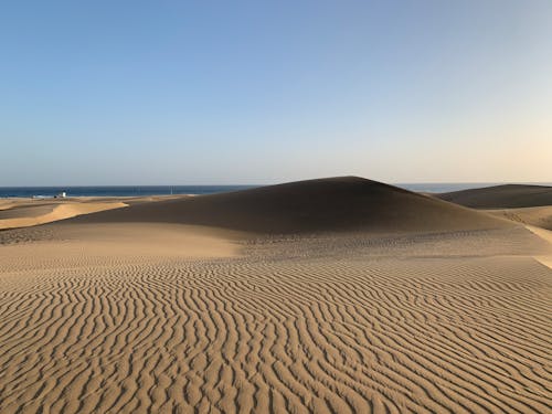 Brown Sand Field Under Blue Sky