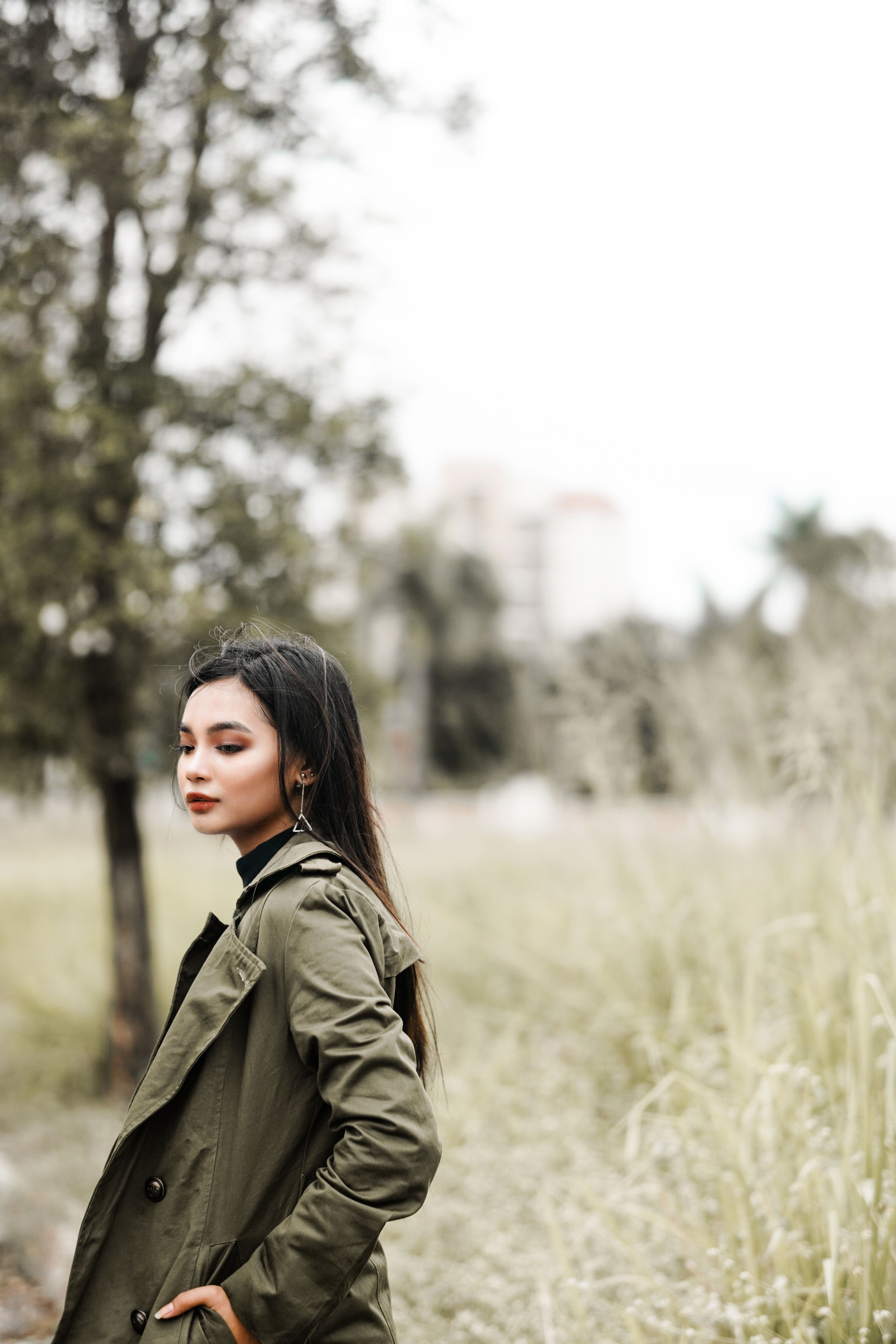 Woman in Green Jacket Standing on Grass Field · Free Stock Photo