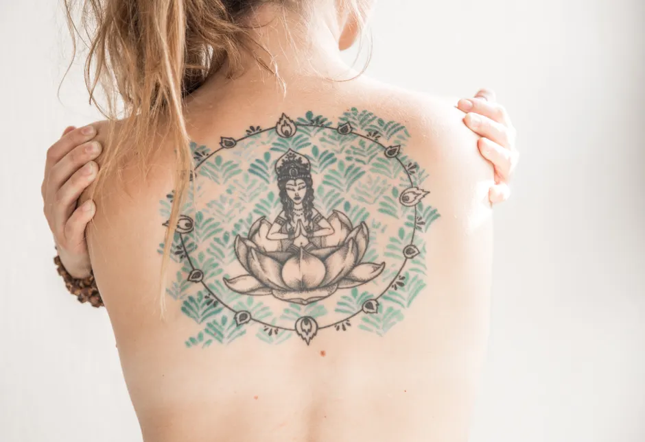 Tatouage lotus et déesse dans le dos, symbole de pureté et d'éveil spirituel