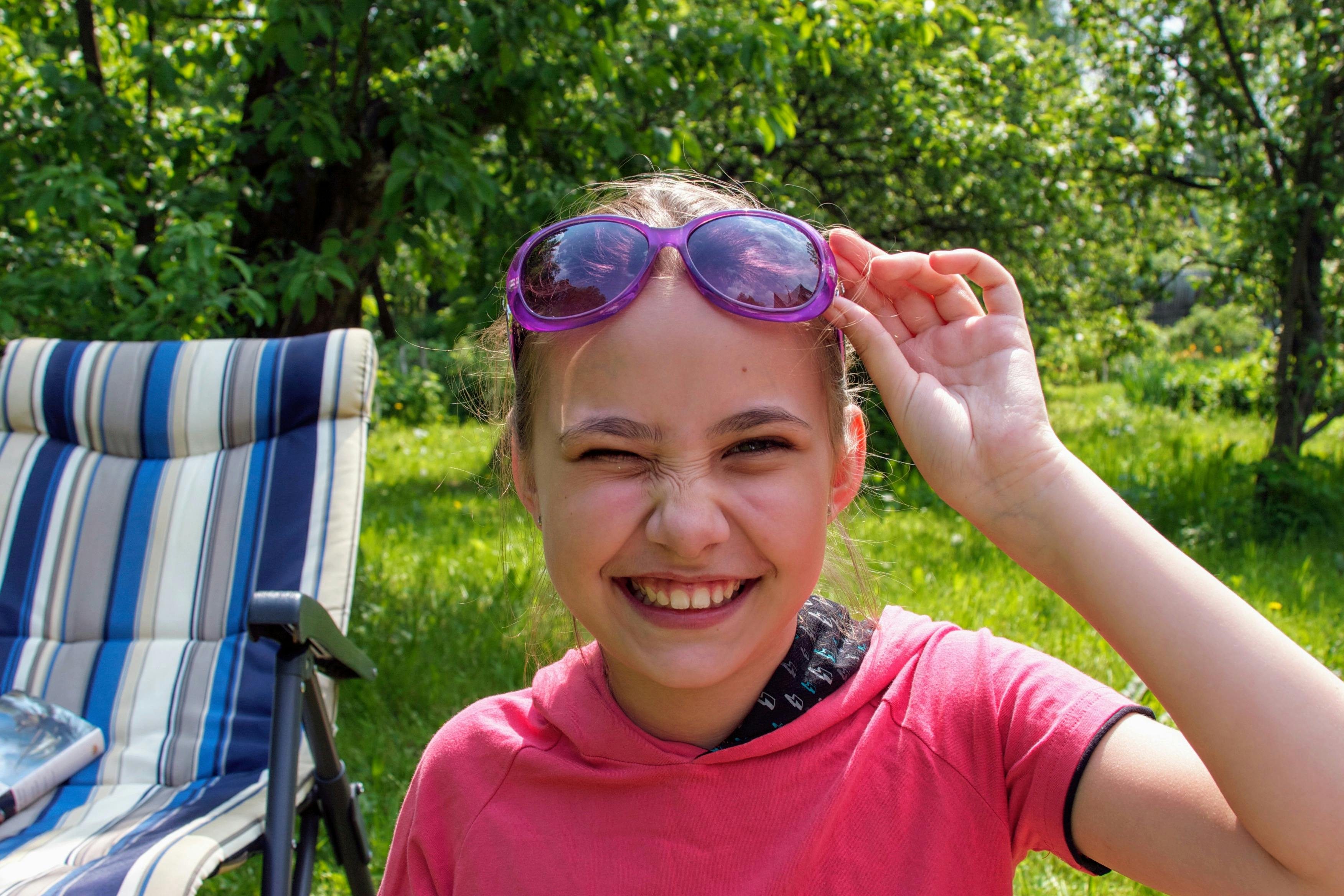 girl in pink hoodie and purple framed sunglasses