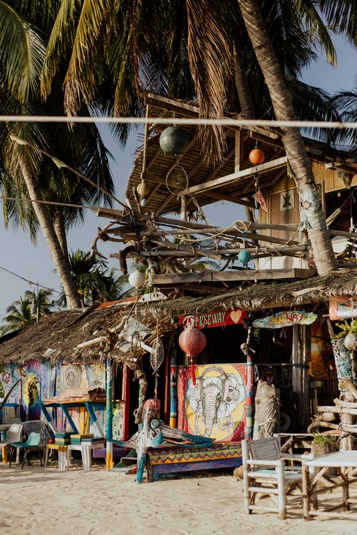 Free Vibrant beach shack under palm trees with artistic decorations, perfect for a tropical vacation vibe. Stock Photo