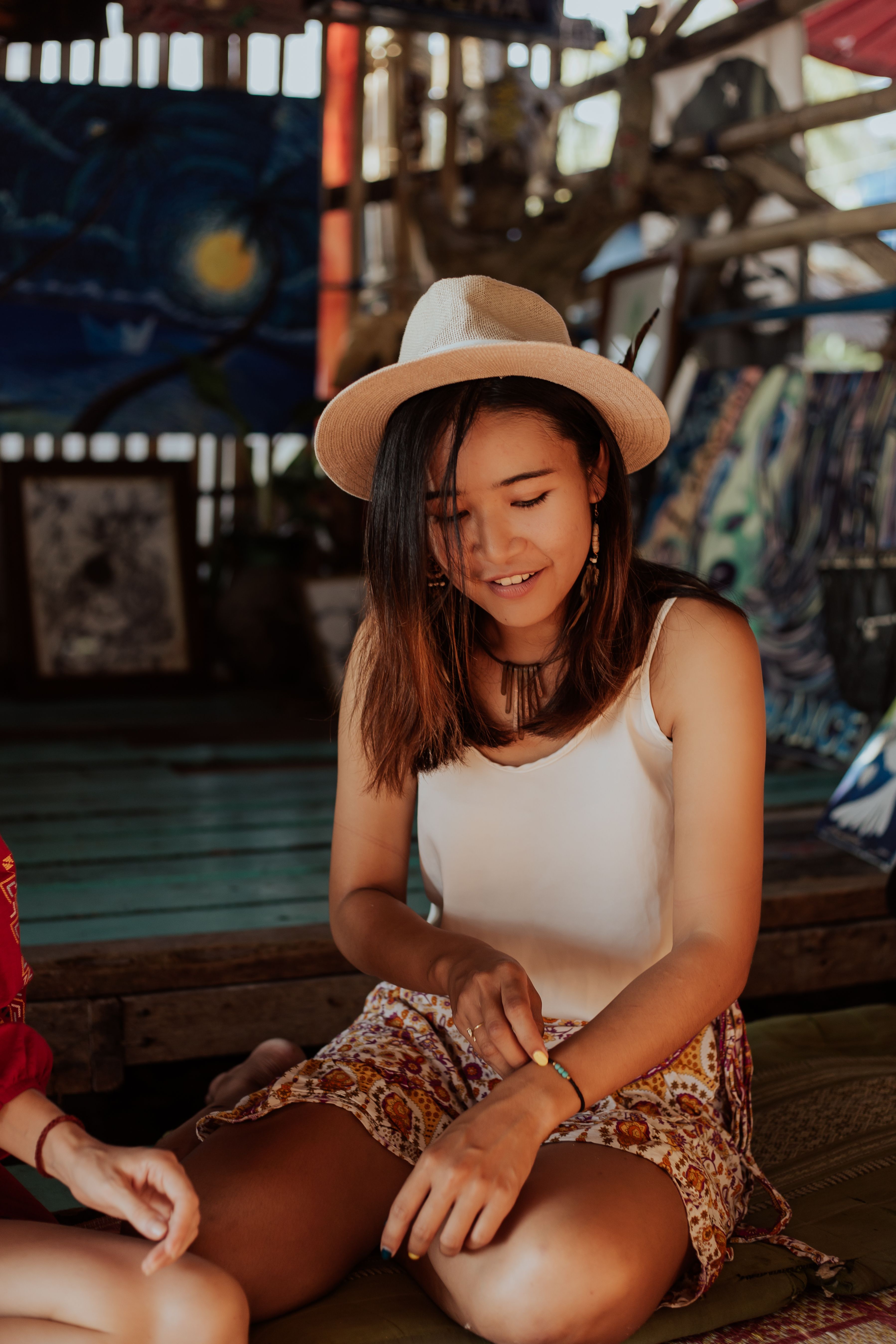 Young Woman in a Hat Sitting on the Floor and Smiling · Free Stock Photo