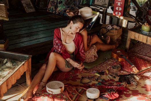 在波西米亚风格的室内市场里，两名妇女正悠闲地逛着，周围摆满了各式各样的商品