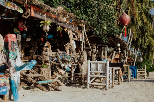 Free A rustic beach bar adorned with eclectic bohemian decor along a tropical sandy shore. Stock Photo