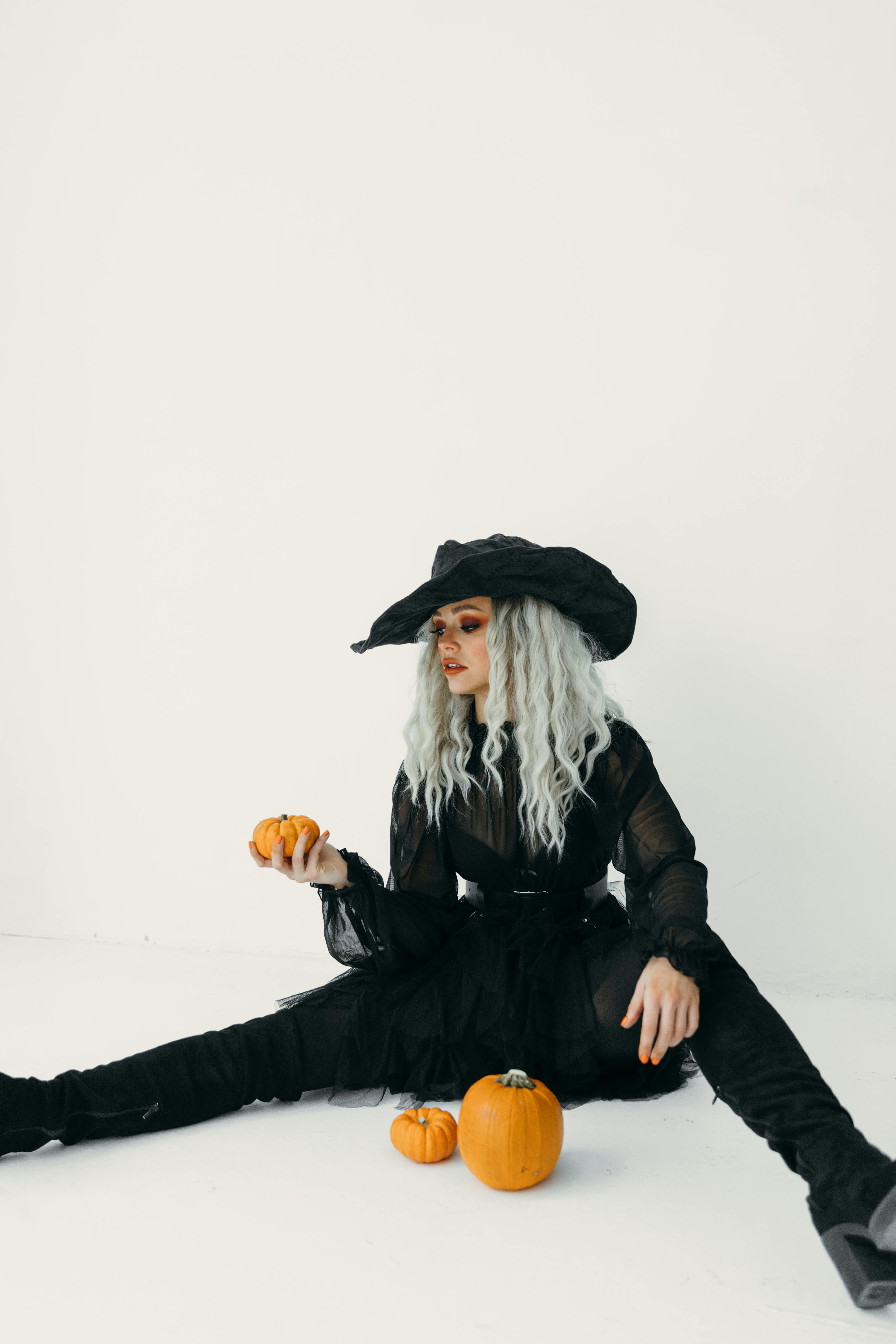 woman in black holding a pumpkin