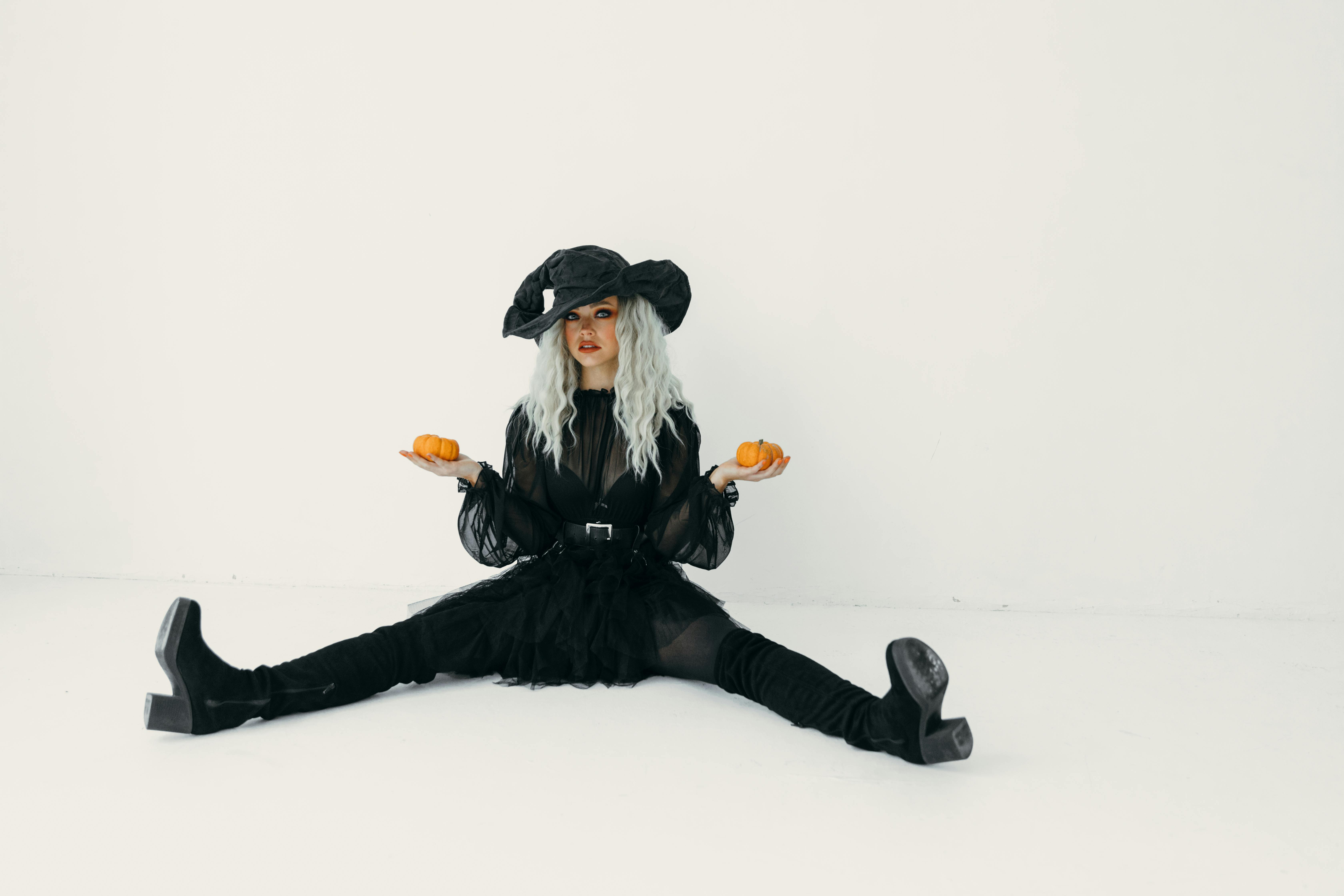 woman in black holding two pumpkins