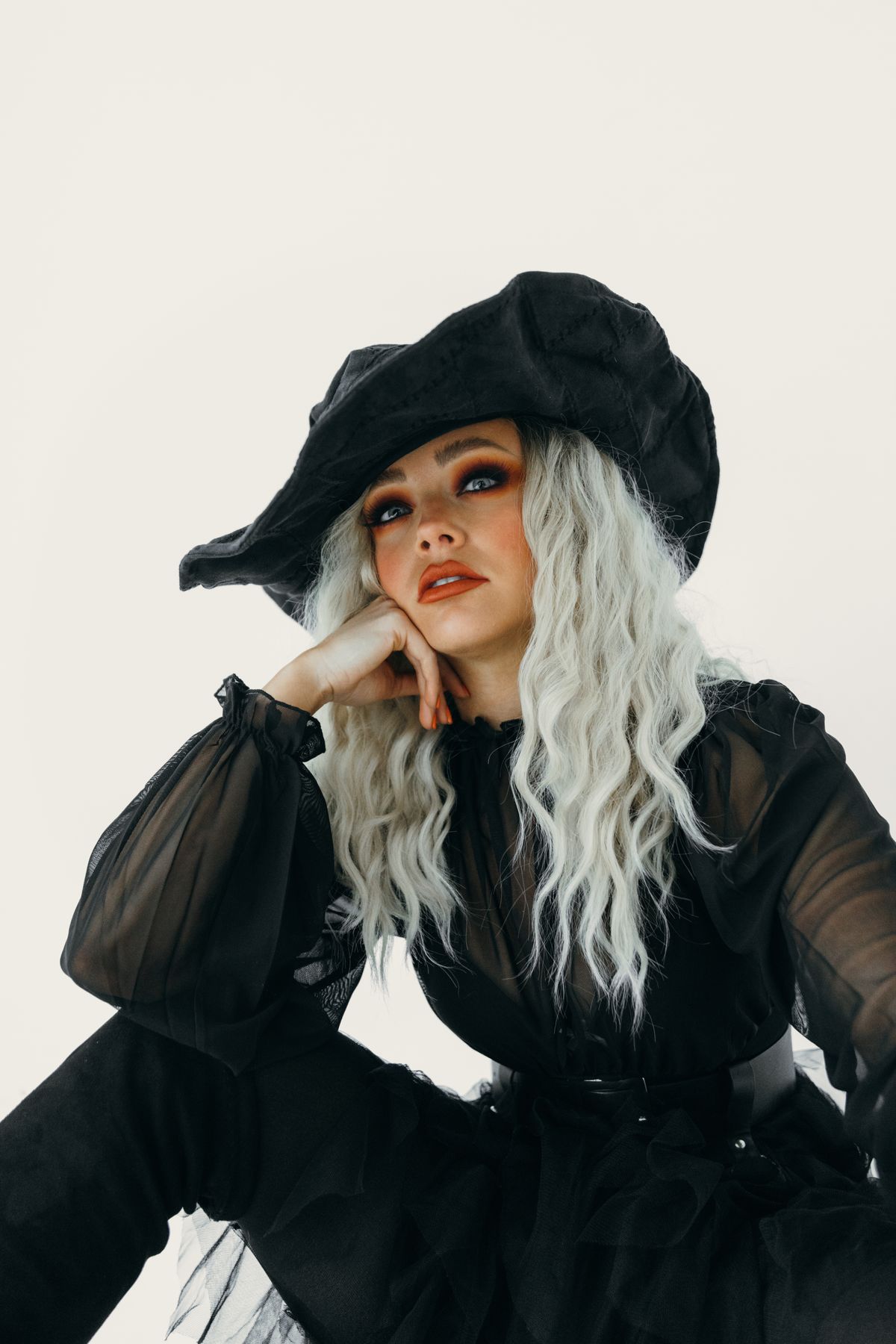 Adult woman in a black witch costume with a pointed black hat for halloween costume ideas for adults