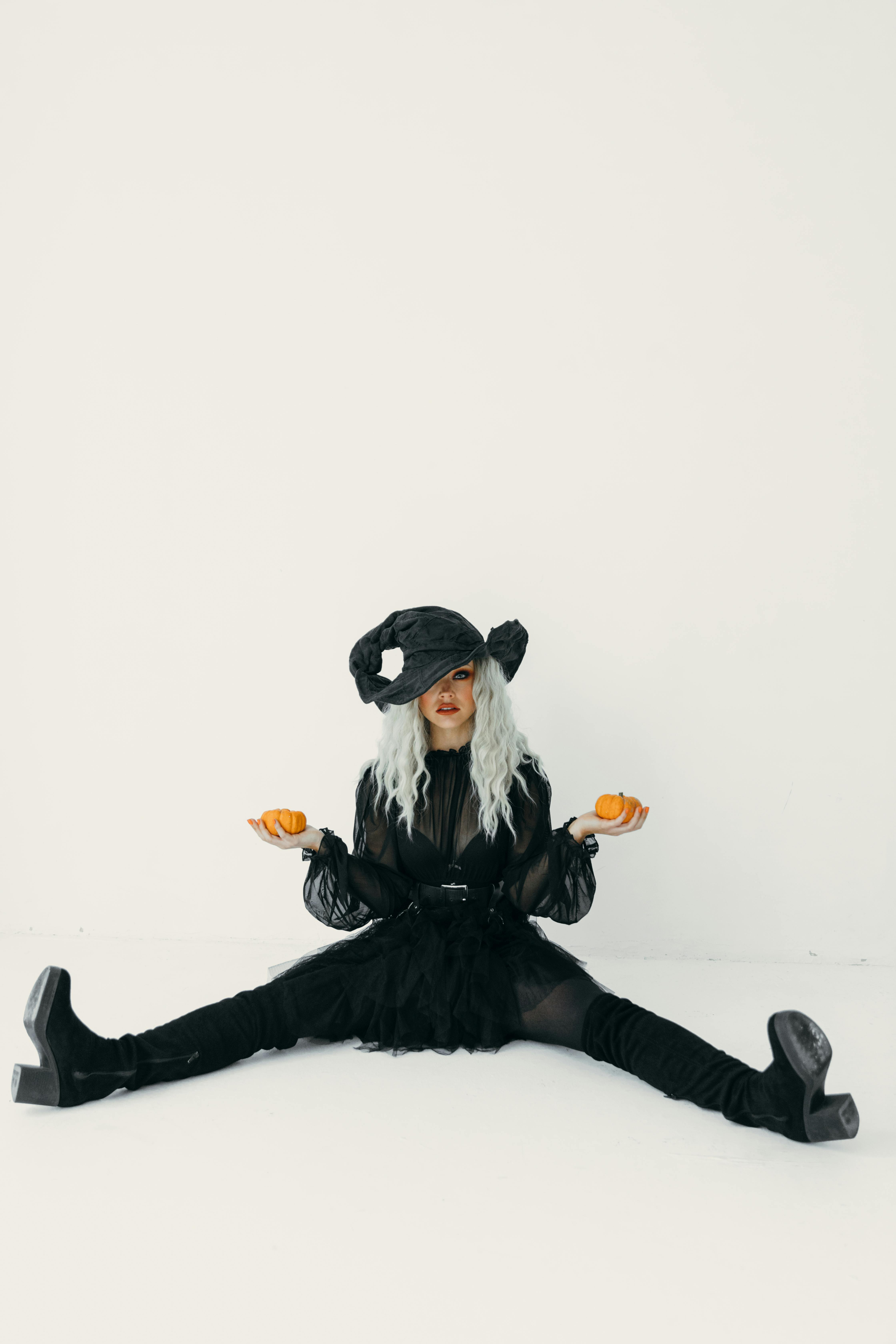 woman holding pumpkins while sitting on the floor