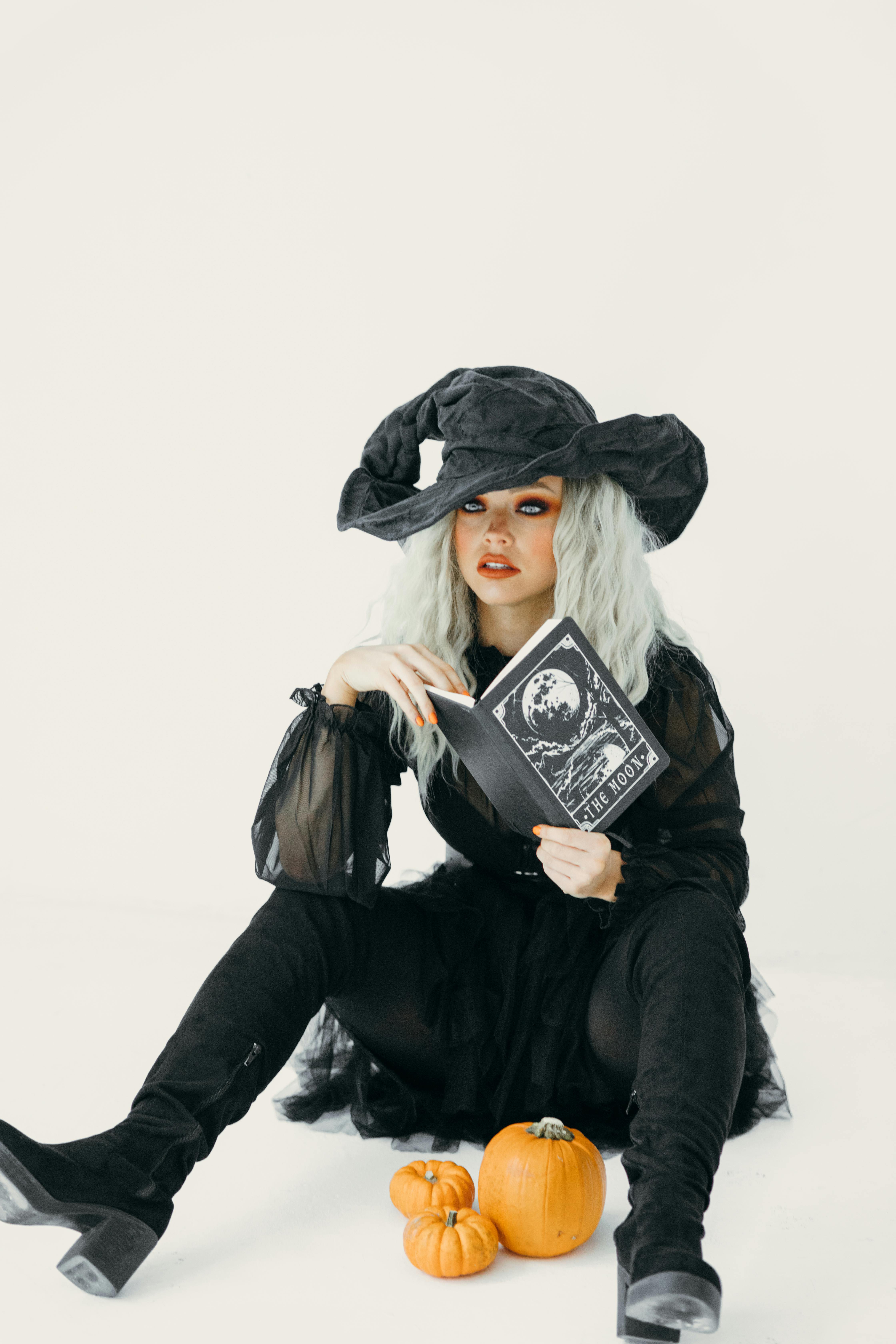 woman in a witch costume holding a book